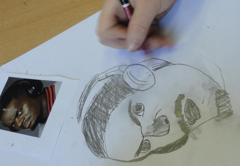 hand met potlood en getekend portret