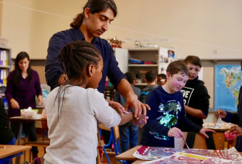 Kunstenaar Ali in dialoog met de kinderen die tekenen